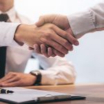Real estate broker agent and customer shaking hands after signing contract documents for realty purchase, Bank employees congratulate, Concept mortgage loan approval