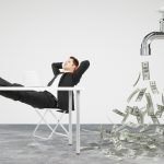 Businessman resting on a chair and faucet from which the money f